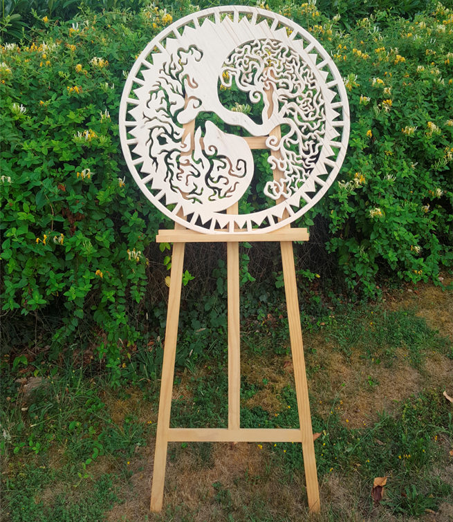 Wooden handcrafted mandala on stand in the bushes